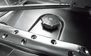 Inside a Hobart hood dishwasher showing stainless steel wash arms and a salt container cap
